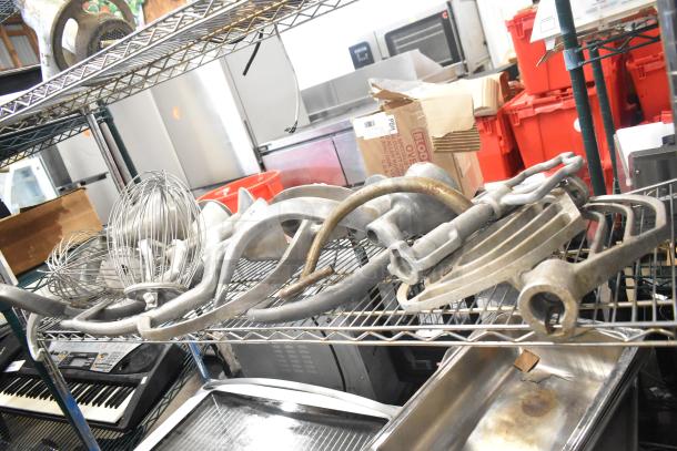 15 Hobart Mixer Attachments on shelf, includes dough hooks, paddle whips, and whisks. Used condition.