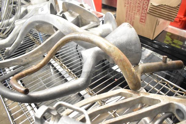 15 Hobart mixer attachments, including dough hooks, paddle whips, whisk. Metal, used condition, minor rust.