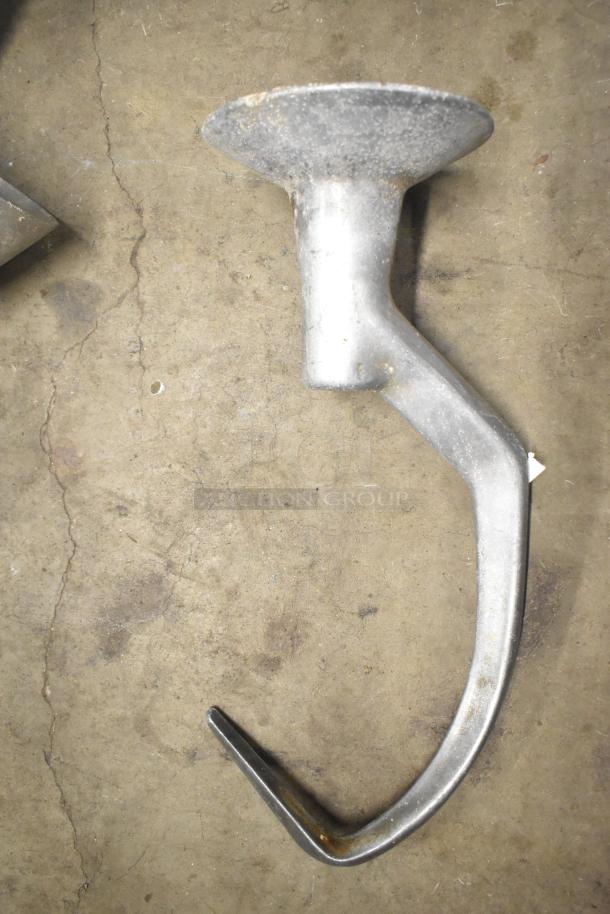 15 various attachments for Hobart mixer, including dough hooks, paddle whips, and whisk, shown in used condition.