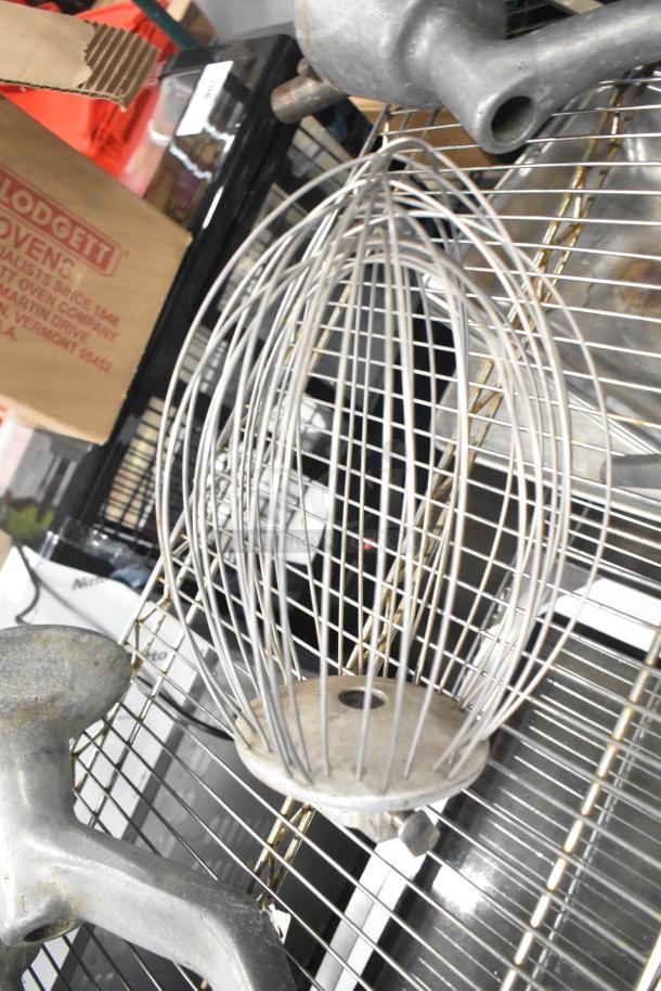 15 various attachments for Hobart mixer, including dough hooks, paddle whips, whisk, in used condition.