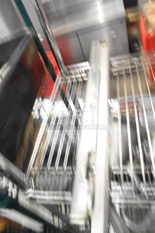 Blurred image of an industrial stainless steel burner and shelving. Specific features and condition unclear.