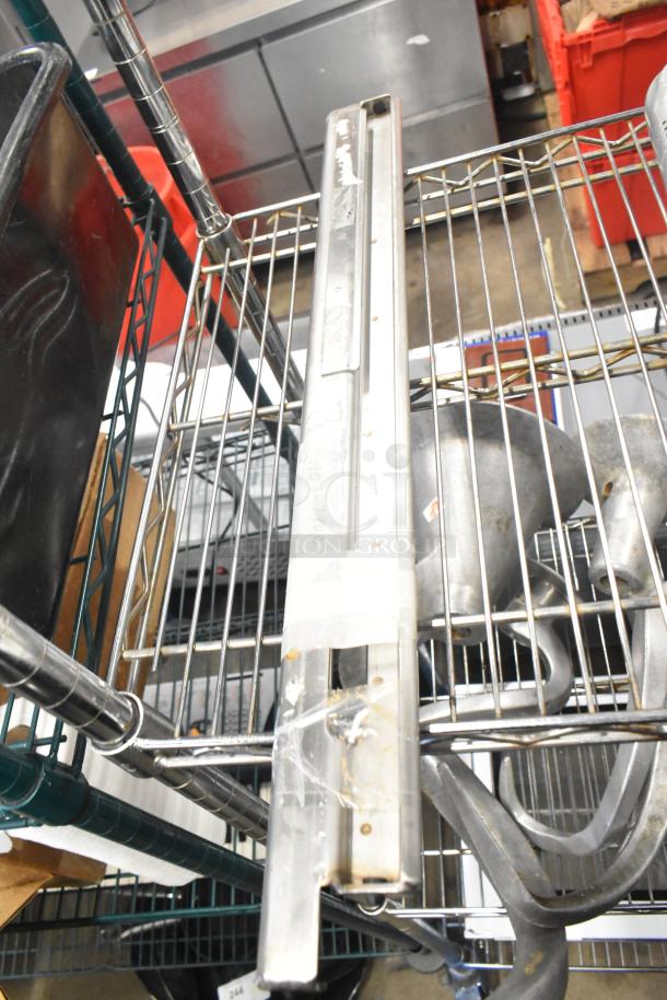 Metal burner and cylindrical item on wire shelf, fair condition. Tape and markings visible on burner indicate prior use.