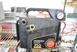 Duracell Jump Starter and Compressor, 750 peak amps, with pressure gauge, well-used, dual charging ports, and safety switch.
