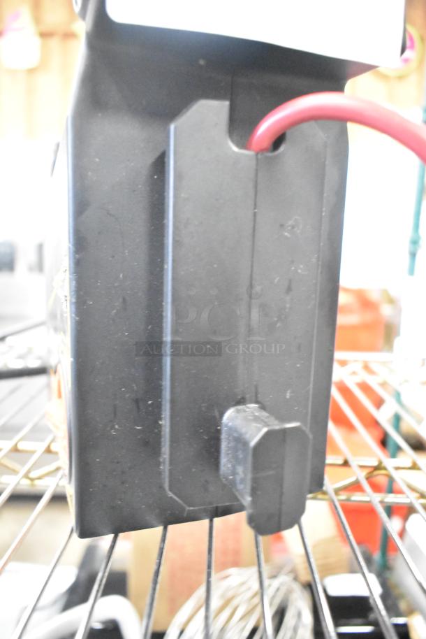 Duracell jump starter and compressor, visible power cable, housed in sturdy black casing, appears in good condition.