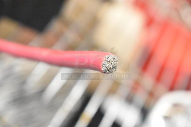 Close-up of a red cable end, possibly part of the Duracell Jump Starter and Compressor, showing detailed wiring condition.