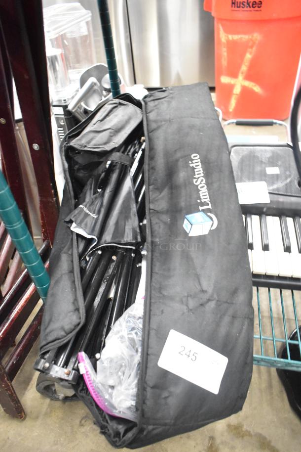 LimoStudio photography setup with black carrying bag, includes tripods and umbrellas, condition appears used.