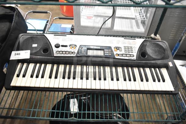 Yamaha PSR-175 Keyboard with built-in speakers, control panel, and display. Minor wear on keys. Label indicates auction item 246.