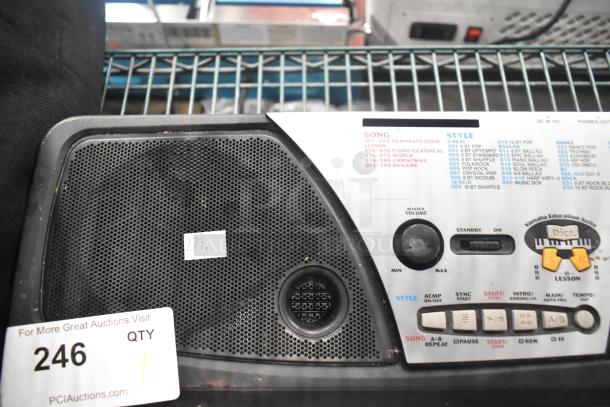 Yamaha PSR-175 Keyboard, visible controls and speaker. Includes song and style list with volume knob. Auction tag "246".
