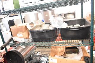 Tiered shelf with various items: white ceramic ramekins, black poly bus bins, cardboard boxes, some with labels.