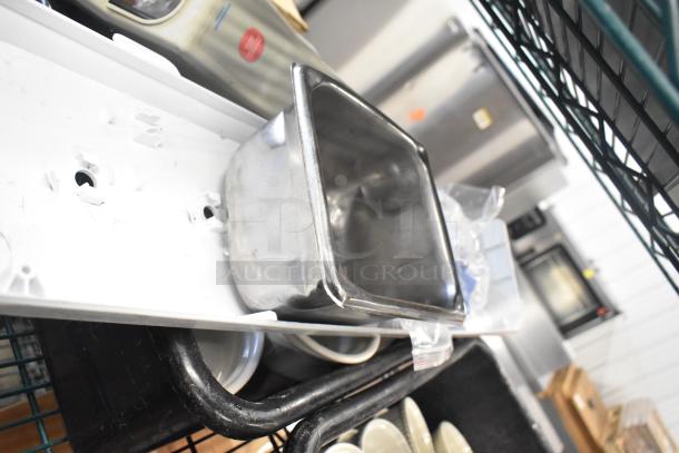 Auction lot with white ceramic ramekins and black poly bus bins, showing some visible wear, stacked on a shelf.