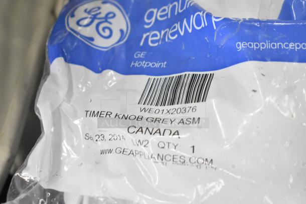 GE Hotpoint timer knob in original packaging. Label reads "Timer Knob Grey ASM, Canada, Sep 23, 2014". Barcode and website visible.