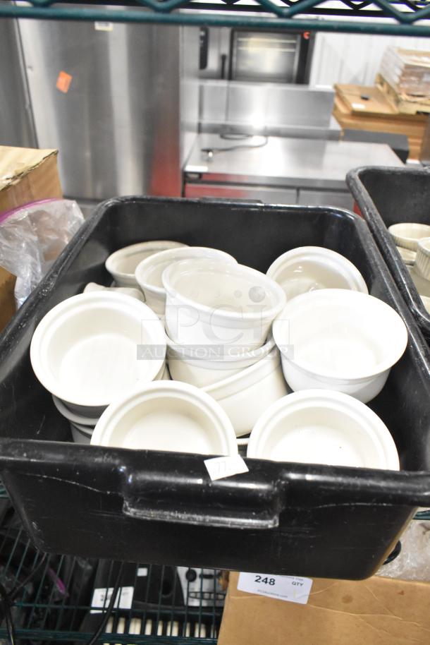 Tier lot with white ceramic ramekins in a black poly bus bin. Ramekins appear in good condition. Auction item tag visible.