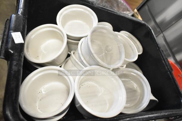 Tier lot of white ceramic ramekins in black poly bus bin. Ramekins show minor wear. Label marked with 377.