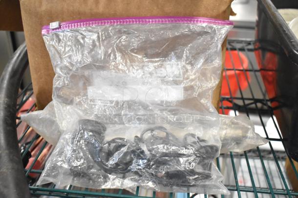 Clear plastic bag with black hardware, placed on a wire shelf. No visible markings. Part of auction lot.
