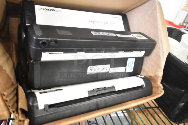 Box with black and white electronic devices, labeled "ROADWARRIOR X3". Black poly bus bins partially visible.