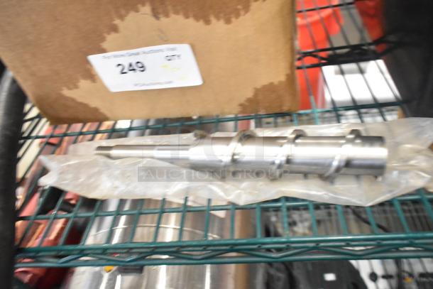 Assorted auction items on a shelf including metallic tool, cardboard box with lot number 249, and other miscellaneous objects.