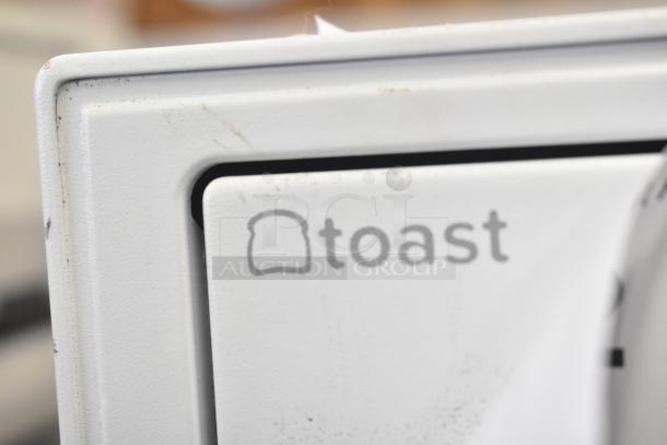 White cash drawer with "toast" logo. Visible wear and marks. Part of an 8-item auction lot.
