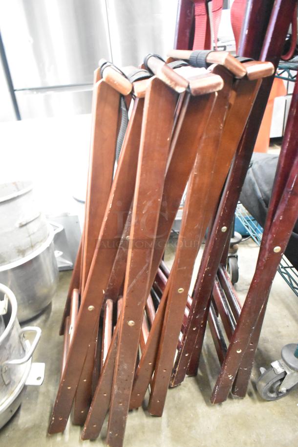 5 brown wooden serving tray stands, foldable design, showing slight wear. Bidding includes all five stands.
