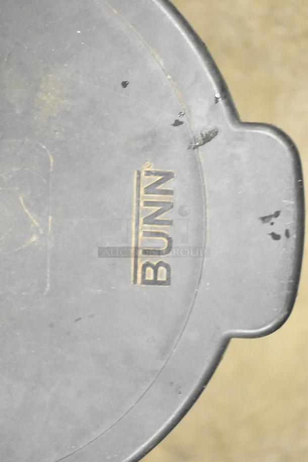 Bunn Countertop Beverage Holder Dispenser, gray with visible Bunn logo, shows signs of wear and minor surface scratches.