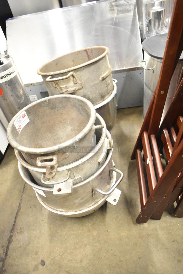 Five various metal mixing bowls, stacked. Slightly worn condition with visible handles and securing tabs. Auction label attached.