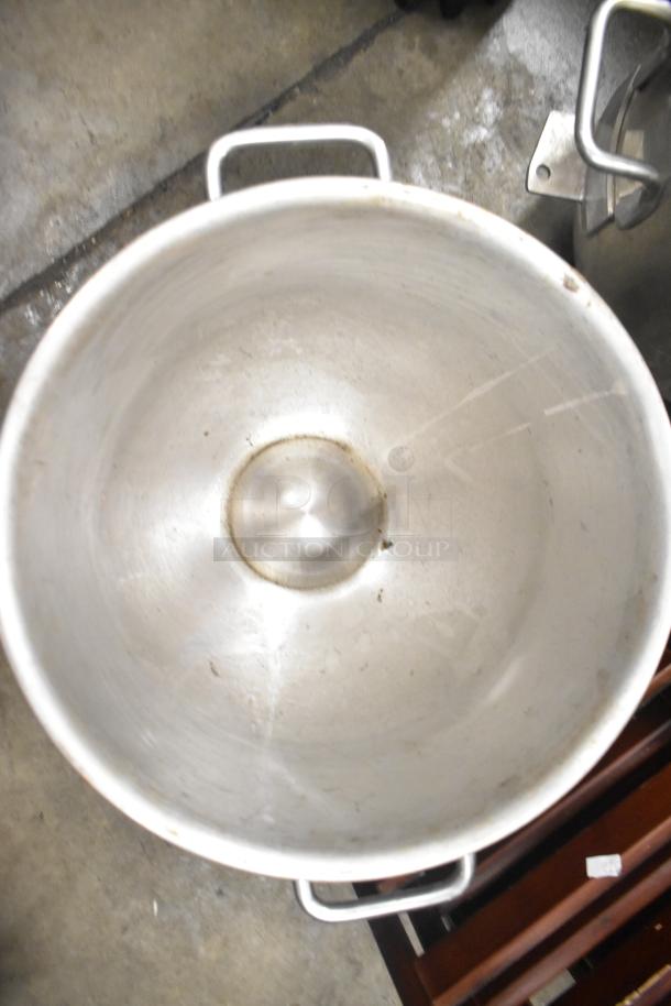 Five metal mixing bowls with handles, used condition, minor scratches visible. Ideal for commercial or home use.