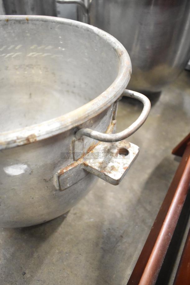 Five metal mixing bowls with handles, in used condition. Visible rust and wear indicate age.