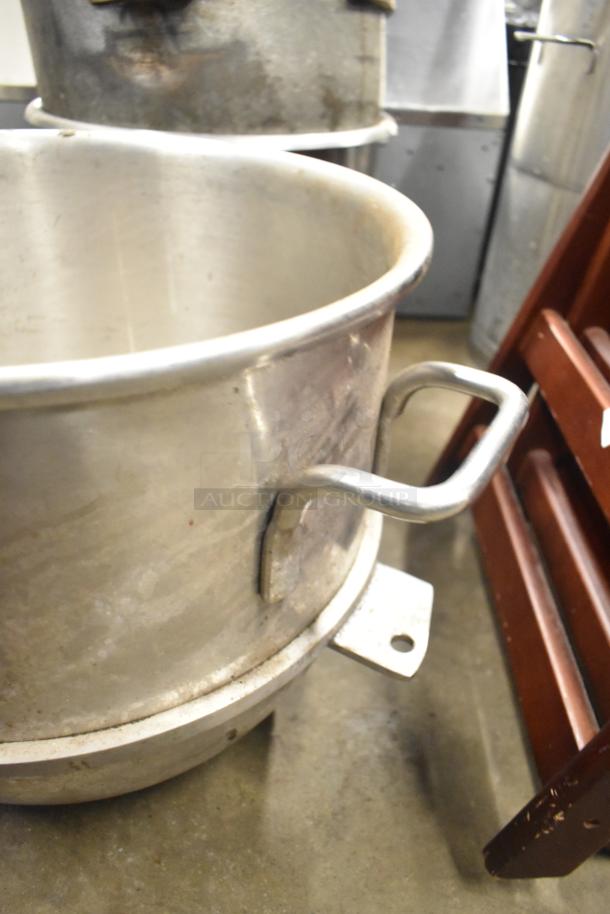 Various metal mixing bowls with handles, showing signs of wear. Ideal for heavy-duty kitchen use. Auction includes five bowls.