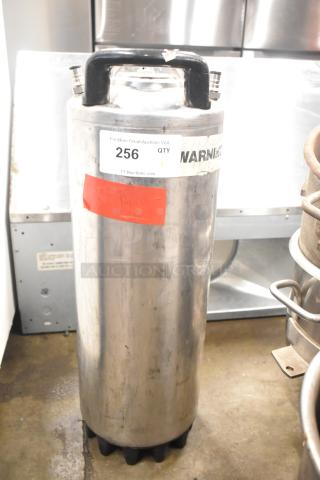 Stainless steel ball lock keg with black handles, visible wear; auction label "256" affixed; ideal for homebrewing.