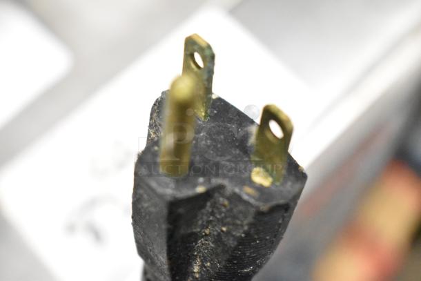 A close-up of a three-pronged plug.