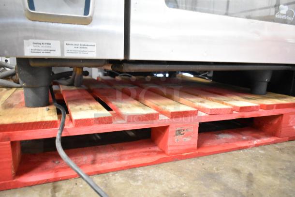 Rational CMP62G CombiMaster Plus gas convection oven with stand, visible cooling air filter label, on red pallet.