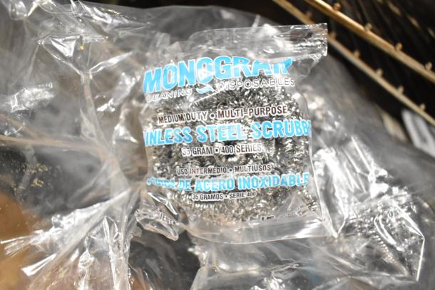 Stainless steel scrubber pack labeled "Monogram Cleaning Disposables." Poly wrap packaging visible.
