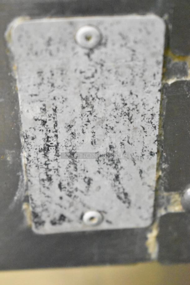 Close-up of a worn metal label on a Vulcan convection oven, showing signs of age and use.