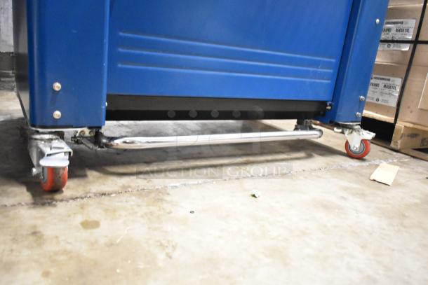 Polychem PC1000 strapping machine on casters, blue body, 115V, floor style, used condition.