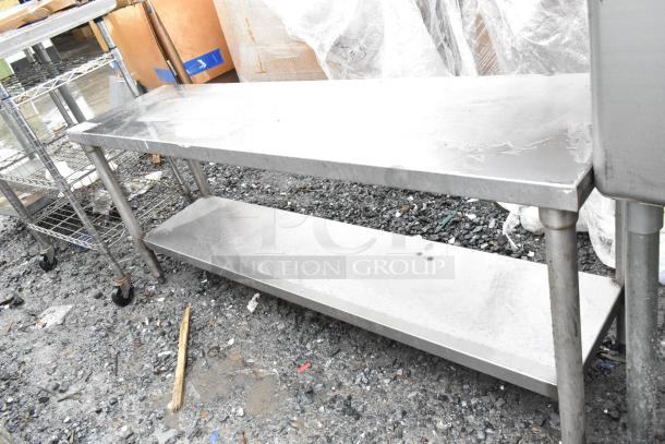Stainless steel commercial table with under shelf, used condition. Durable metal construction, ideal for kitchen or storage use.