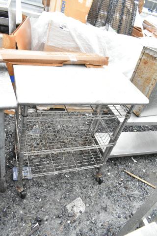 Commercial table with 3 wire shelves and commercial casters, metal construction, ideal for storage or kitchens, used condition.