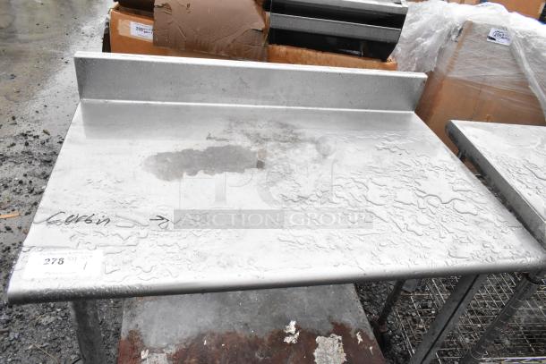 Stainless steel commercial table with under shelf, back splash, minor wear. Auction label “278” visible on surface.