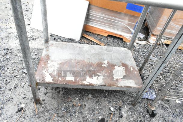Commercial table with under shelf and backsplash, visible rust and wear; Eagle brand label on shelf.