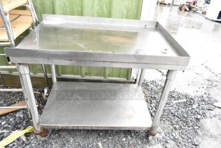 Stainless steel 2-tier cart with commercial casters, used condition, visible wear and rust on wheels, suitable for industrial use.