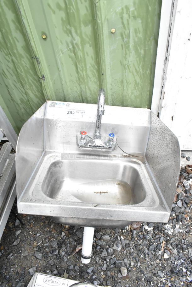 Commercial single bay wall mount sink with faucet, handles, and side splash guards. Stainless steel, used condition.
