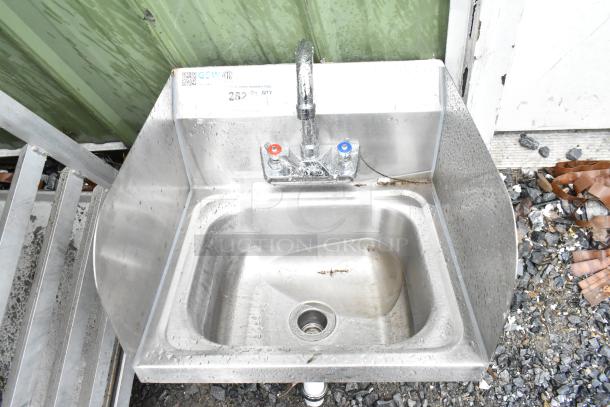 Commercial single bay wall mount sink with faucet and handles, featuring side splash guards. Stainless steel, used condition.