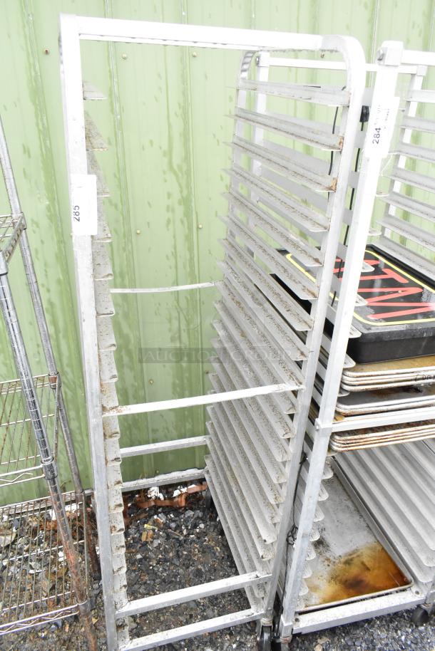 Commercial pan transport rack on casters, metal frame with multiple shelves, visible wear, identification tag labeled "285".