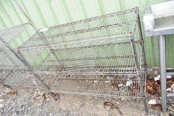 Chrome finish 3-tier wire shelving unit in used condition, outdoors. Buyer must dismantle, consider freight charges.