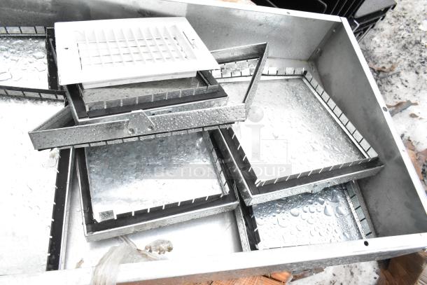Variety of metal panels and components in silver finish, including trays and frames, shown wet with condensation, in good condition.