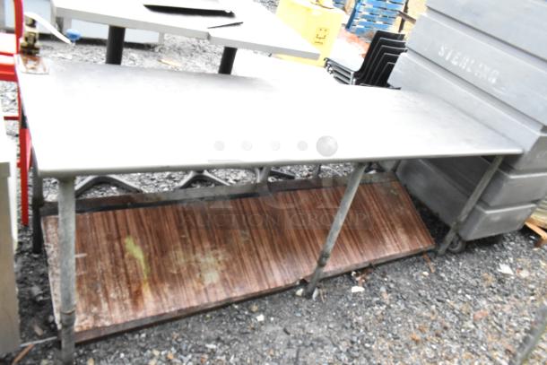 Commercial table with mounted can opener and an under shelf. Signs of wear; rust evident on the lower shelf.