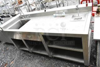 Commercial soda station with water dispenser, sink basin, drawer, and under shelves; stainless steel, used condition.