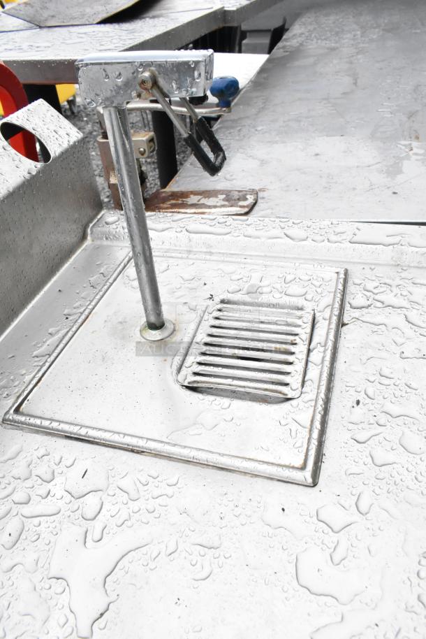 Commercial soda station with water dispenser, sink basin, drawer, and under shelves. Stainless steel, wet surface.