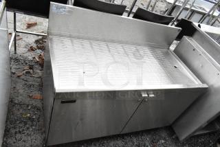 Perlick commercial drain board with doors and under shelf, stainless steel, used condition, prominent grate surface.