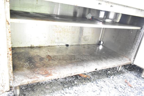 Perlick commercial drain board with doors, visible under-shelf, showing signs of wear and rust.