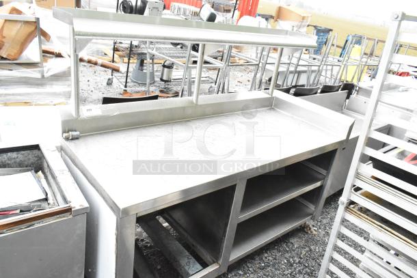 Commercial stainless steel table with over shelf and under shelves. Used, sturdy condition. Perfect for restaurant use.