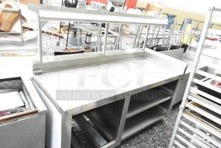 Commercial stainless steel table with over shelf and under shelves. Used, sturdy condition. Perfect for restaurant use.